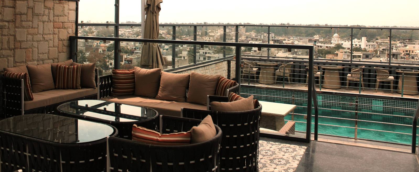 A rooftop lounge with a spacious patio and an adjacent swimming pool at BluSalzz Residence, Amritsar
